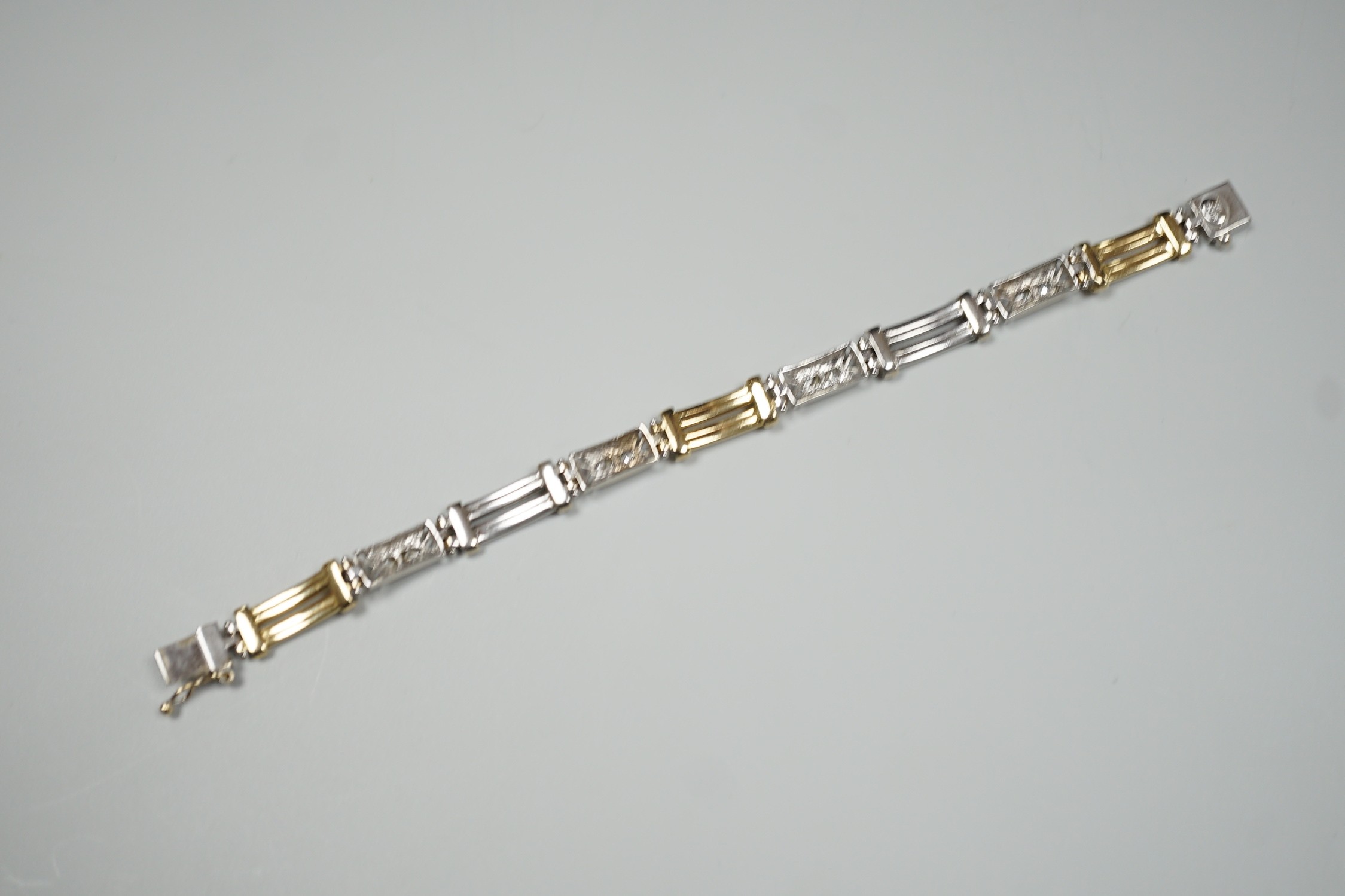 A modern two colour 585 and twelve stone diamond set bracelet, 17.75cm, gross weight 19.2 grams.